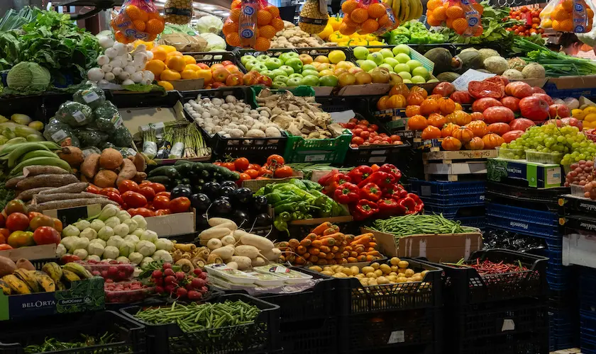 Puesto de frutas y verduras de temporada con producto variado y colorido en un mercado español