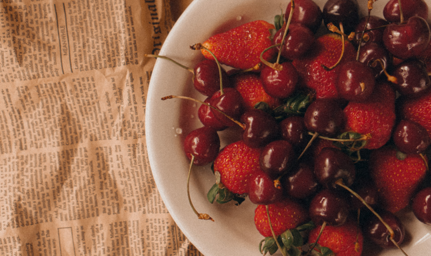 Plato con frutas de primavera como fresas y cerezas